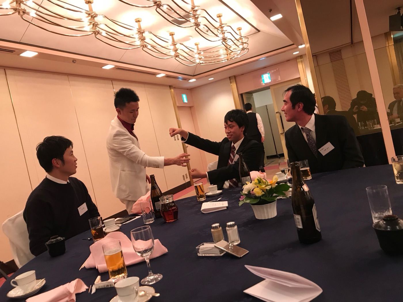ホテル宴会場でテーブルマジックを披露するマジシャン橘優